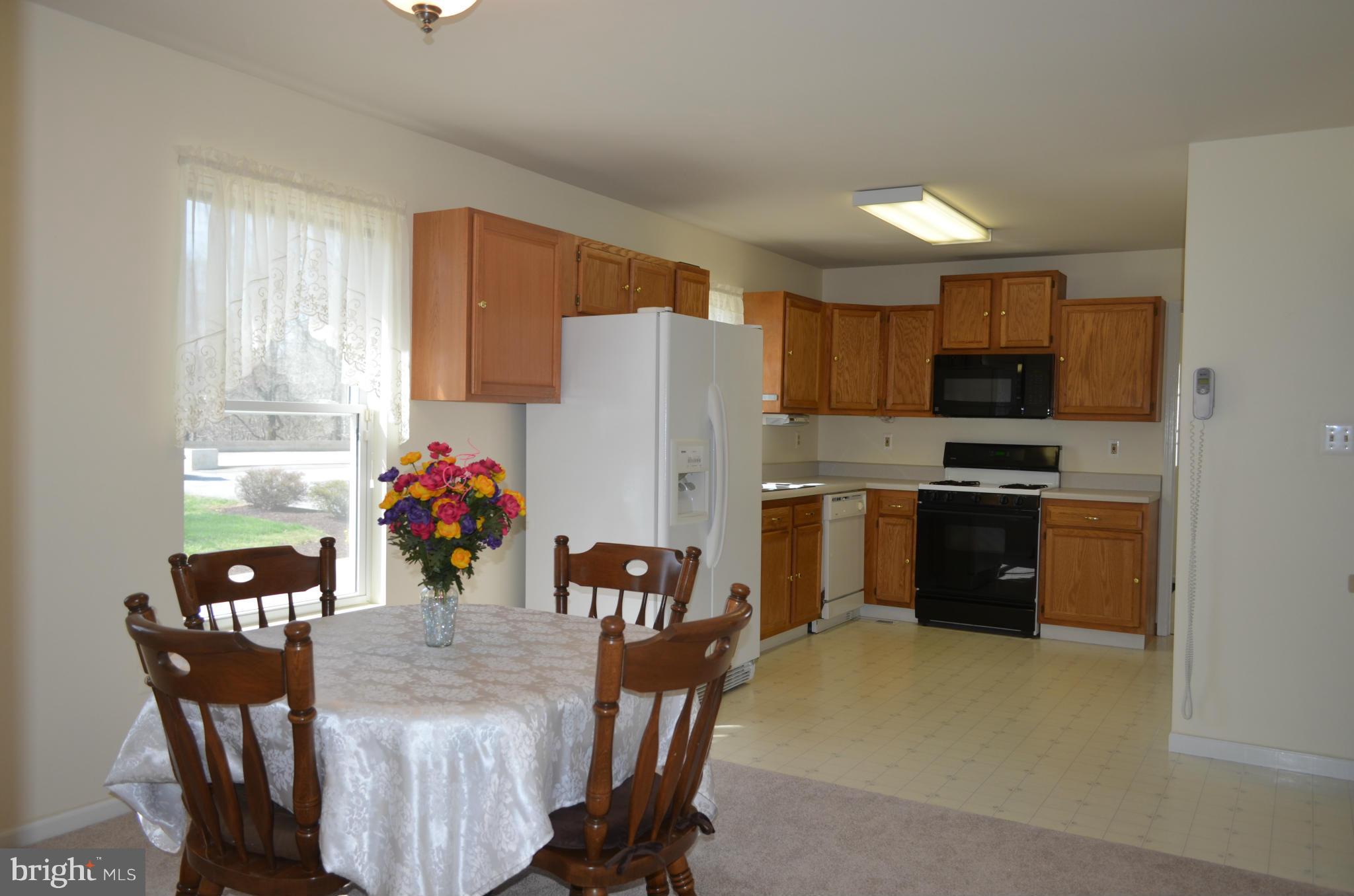 75 Fairhaven Road Tracys Landing, MD 20779 - Photo 8 of 30 a kitchen with stainless steel appliances a refrigerator a stove a microwave a dining table and chairs
