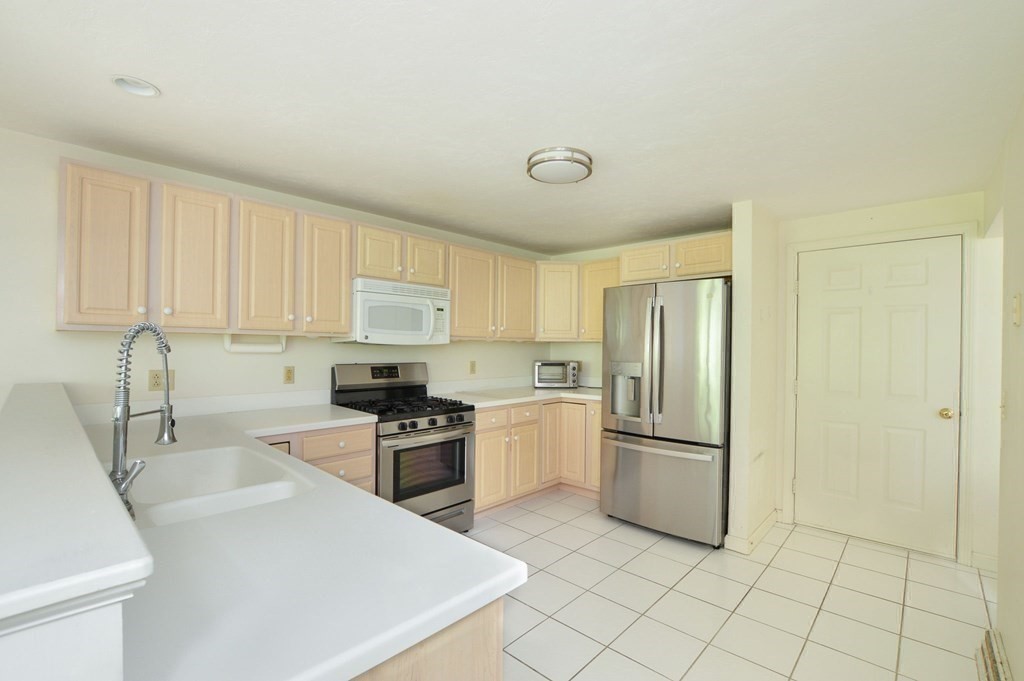 3 Kettle Lane, Unit 3 Mashpee, MA 02649 - Photo 13 of 30 a kitchen with granite countertop a refrigerator stove top oven and sink