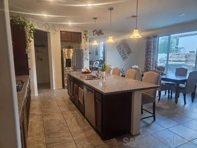 a kitchen with stainless steel appliances granite countertop a sink a counter space and a view of dining table