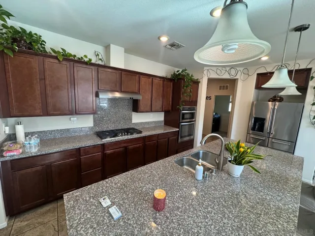 a kitchen with stainless steel appliances granite countertop a stove refrigerator and a dining table with wooden floor