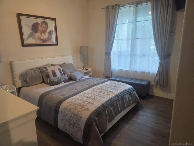 a bedroom with bed and wooden floor