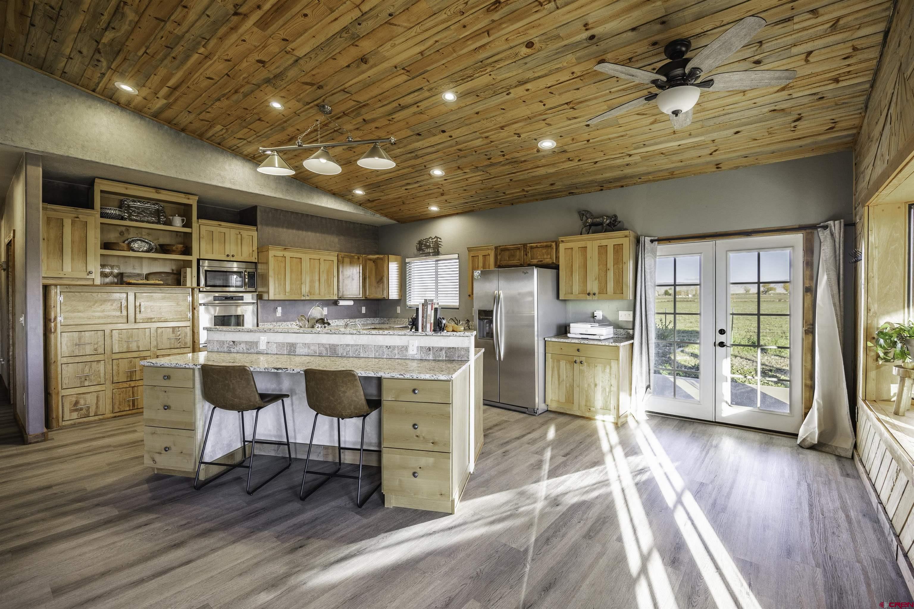 697 Grand Vista Road Delta, CO 81416 - Photo 12 of 44 a kitchen with stainless steel appliances kitchen island granite countertop a table chairs cabinets and wooden floor