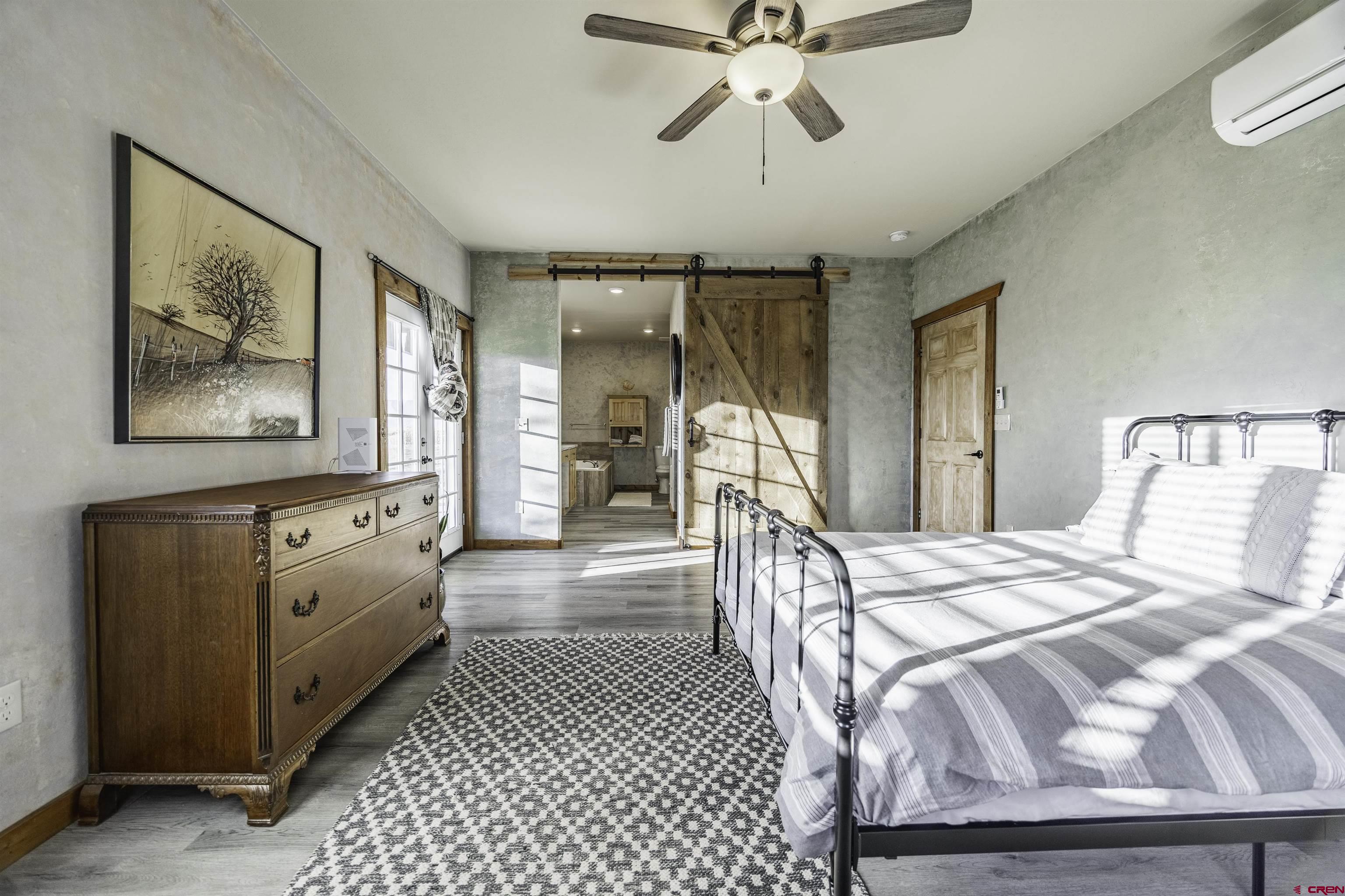697 Grand Vista Road Delta, CO 81416 - Photo 15 of 44 a spacious bedroom with a bed and a chandelier