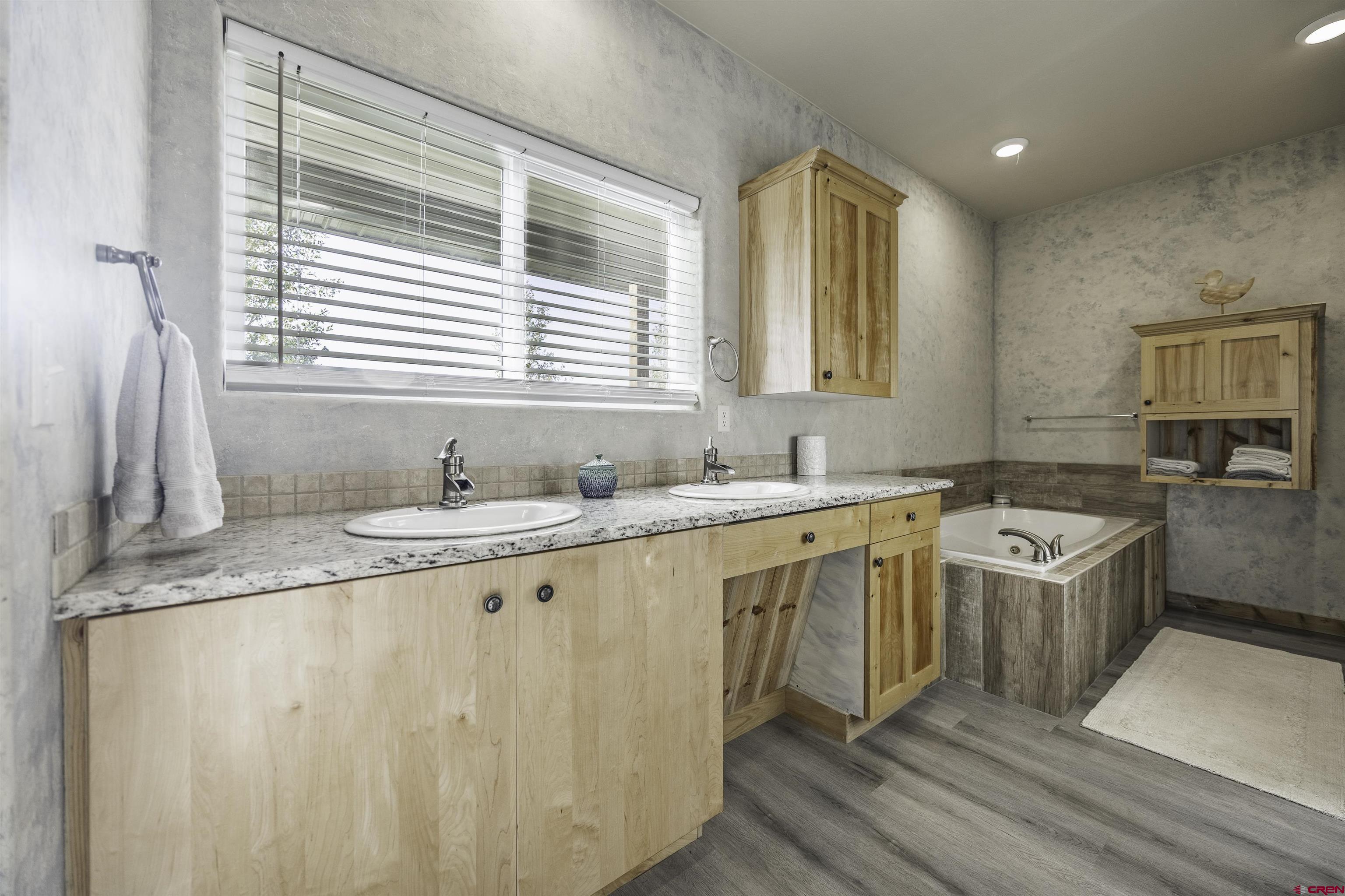 697 Grand Vista Road Delta, CO 81416 - Photo 18 of 44 a spacious bathroom with a granite countertop sink and a large mirror