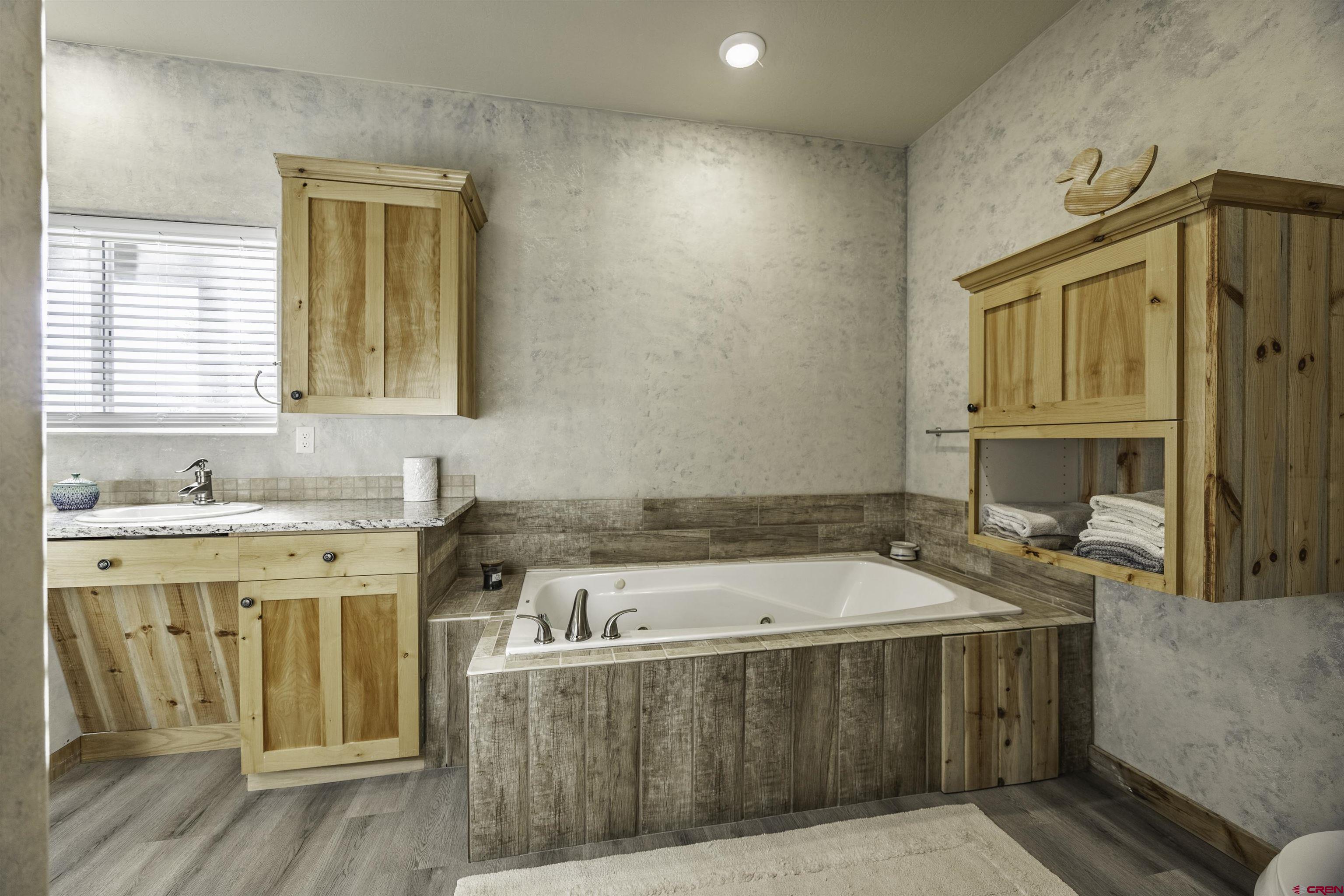 697 Grand Vista Road Delta, CO 81416 - Photo 19 of 44 a bathroom with a tub sink and mirror