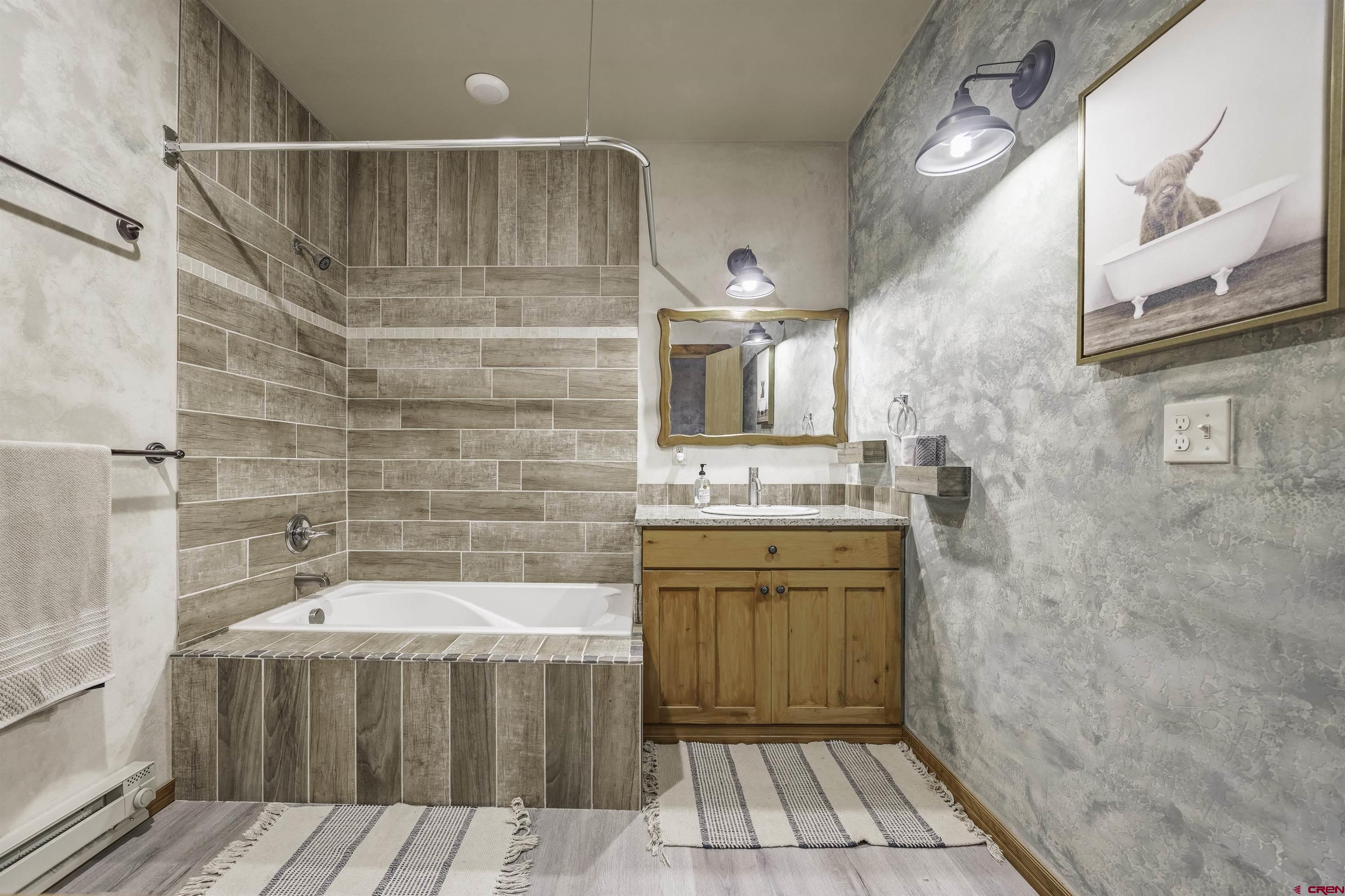 697 Grand Vista Road Delta, CO 81416 - Photo 23 of 44 a bathroom with a sink a mirror and a bathtub