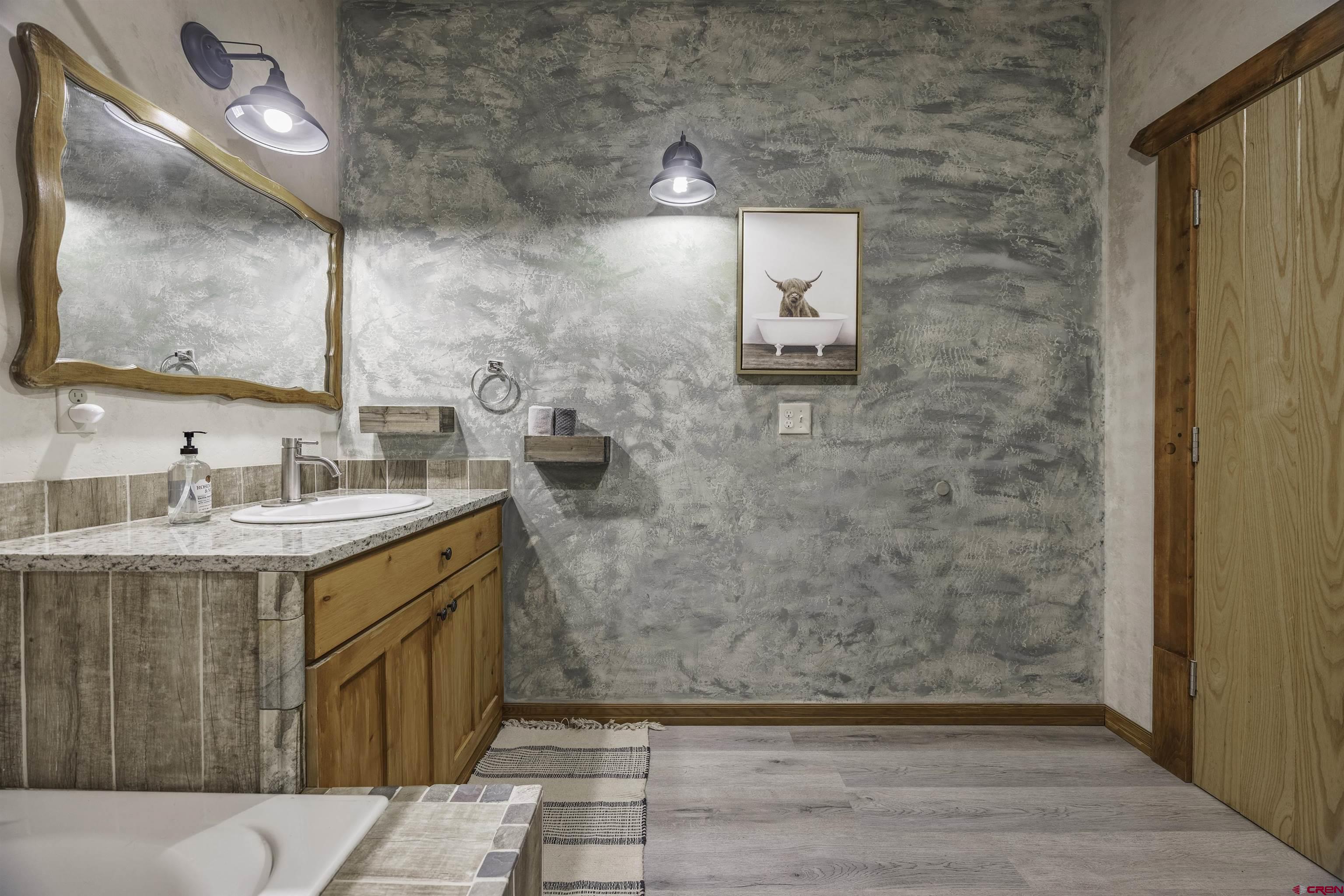 697 Grand Vista Road Delta, CO 81416 - Photo 24 of 44 a bathroom with a sink a mirror and a shower