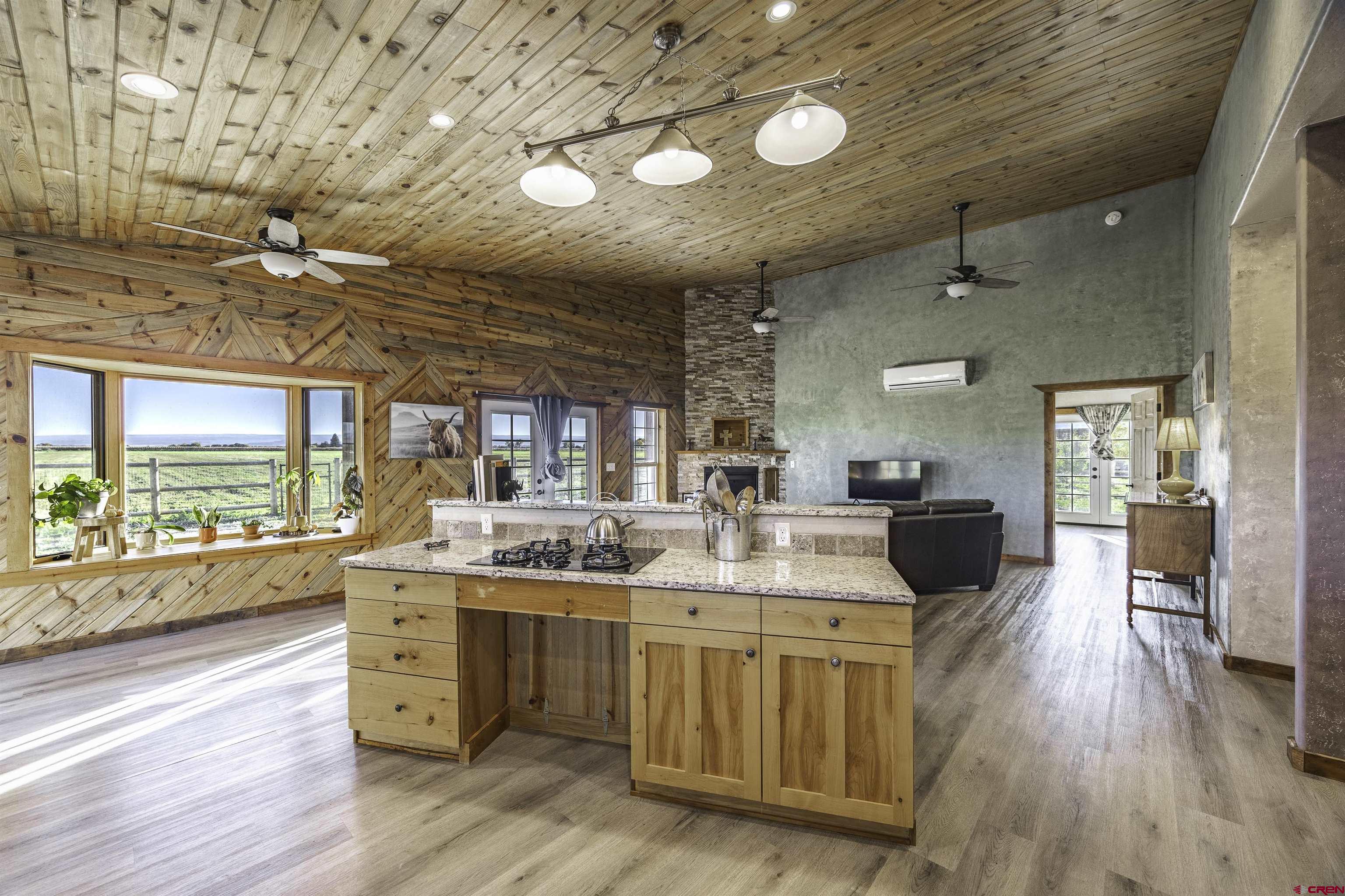 697 Grand Vista Road Delta, CO 81416 - Photo 10 of 44 a large room with stainless steel appliances kitchen island granite countertop a large kitchen island a stove a refrigerator a sink dishwasher and wooden cabinets with wooden floor