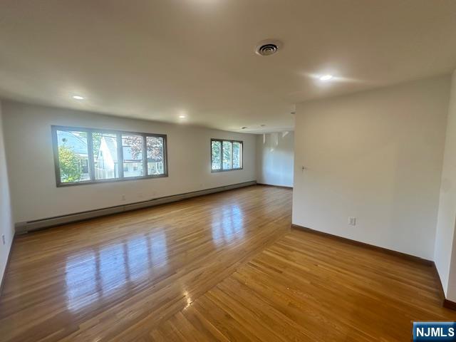 124 Johnson Avenue, Unit 2 Wallington, NJ 07057 - Photo 14 of 17 a view of an empty room with wooden floor and a window