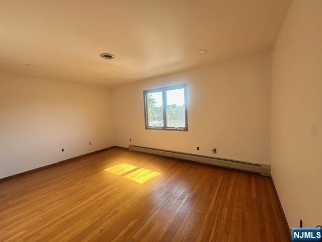 124 Johnson Avenue, Unit 2 Wallington, NJ 07057 - Photo 7 of 17 an empty room with wooden floor and windows