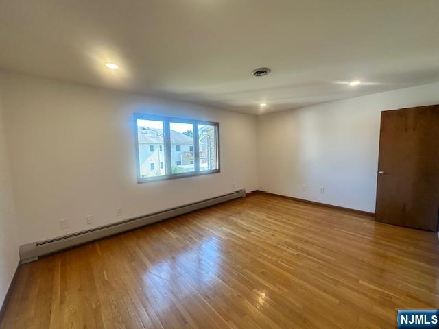 124 Johnson Avenue, Unit 2 Wallington, NJ 07057 - Photo 10 of 17 an empty room with wooden floor and windows