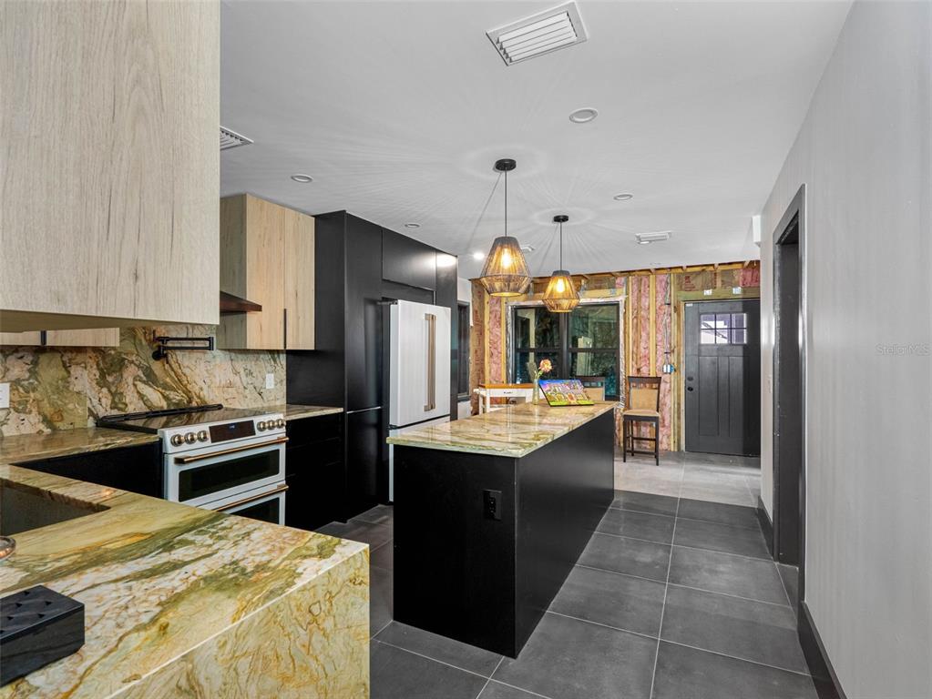 1570 48th Avenue North St. Petersburg, FL 33703 - Photo 23 of 75 a kitchen with stainless steel appliances kitchen island granite countertop a sink and cabinets