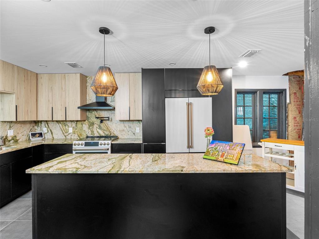 1570 48th Avenue North St. Petersburg, FL 33703 - Photo 25 of 75 a kitchen with kitchen island granite countertop a sink a stove and a wooden floors