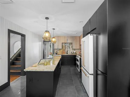 a kitchen with kitchen island white cabinets and stainless steel appliances