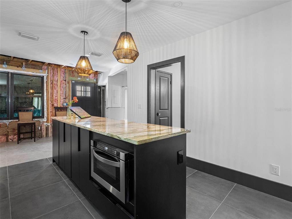1570 48th Avenue North St. Petersburg, FL 33703 - Photo 29 of 75 a kitchen with stainless steel appliances granite countertop a stove and a wooden floors