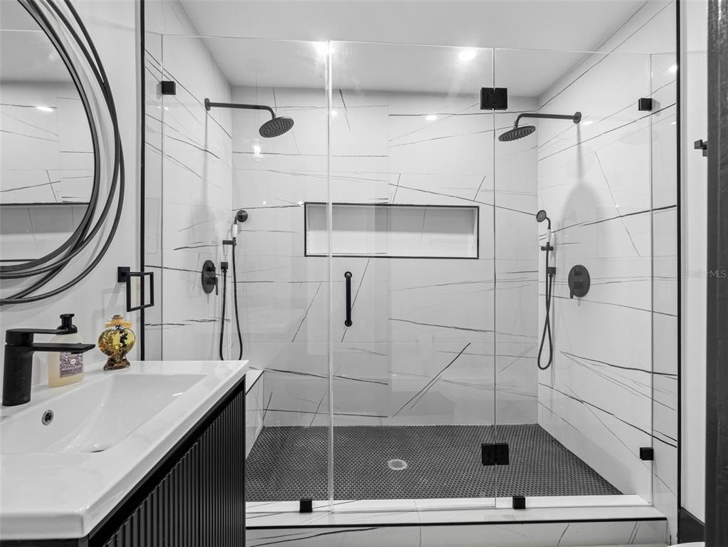 1570 48th Avenue North St. Petersburg, FL 33703 - Photo 32 of 75 a bathroom with a shower sink and mirror