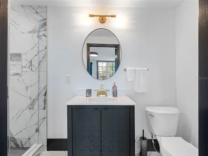 a view of a backyard with plants and large tree