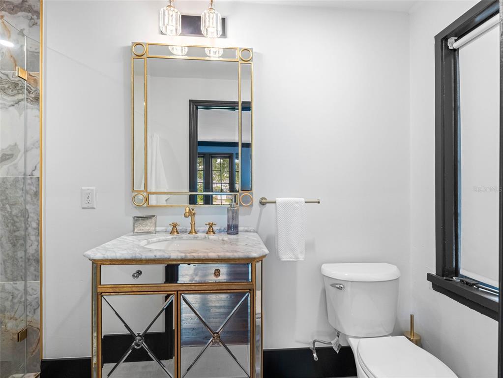 1570 48th Avenue North St. Petersburg, FL 33703 - Photo 40 of 75 a bathroom with a toilet sink and mirror