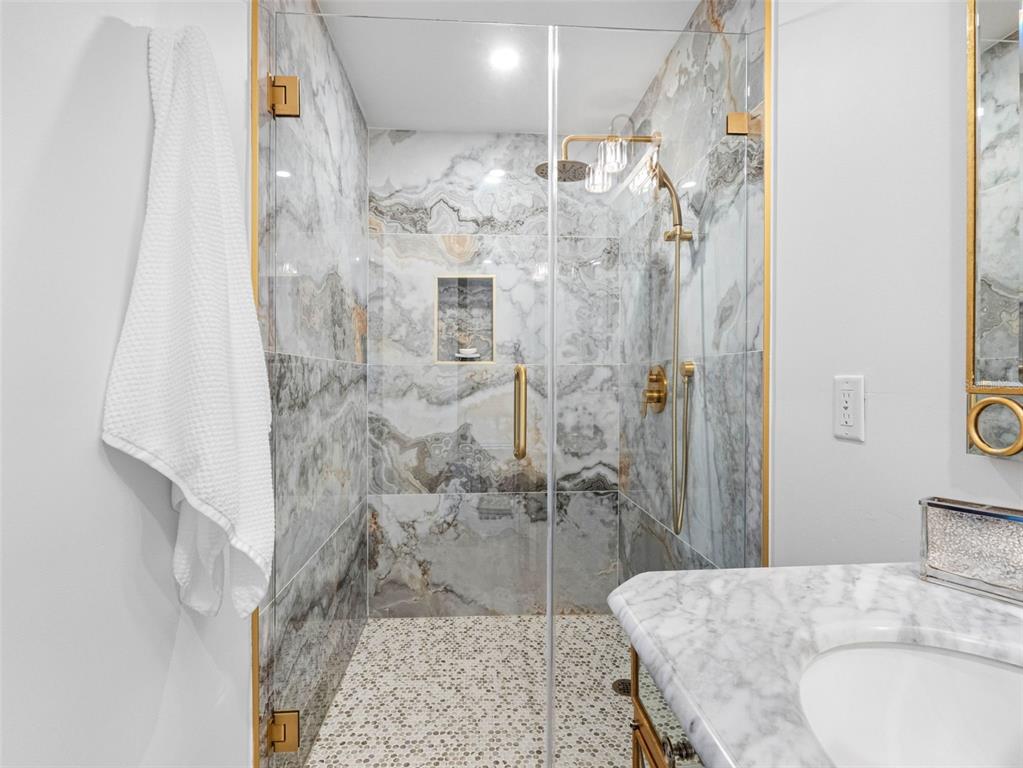 1570 48th Avenue North St. Petersburg, FL 33703 - Photo 41 of 75 a bathroom with a granite countertop shower a sink and a mirror