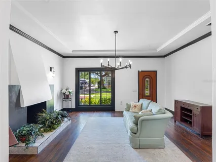 a view of empty room with wooden floor and pendant lights