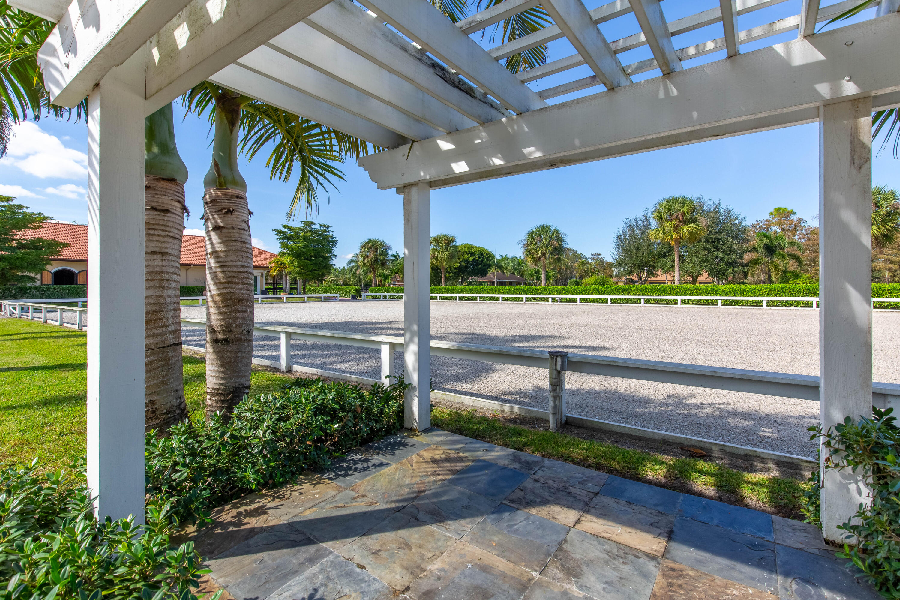 14943 Paddock Drive, Unit STALLS AND ) Wellington, FL 33414 - Photo 14 of 41 a view of a patio with a table and chairs next to a yard