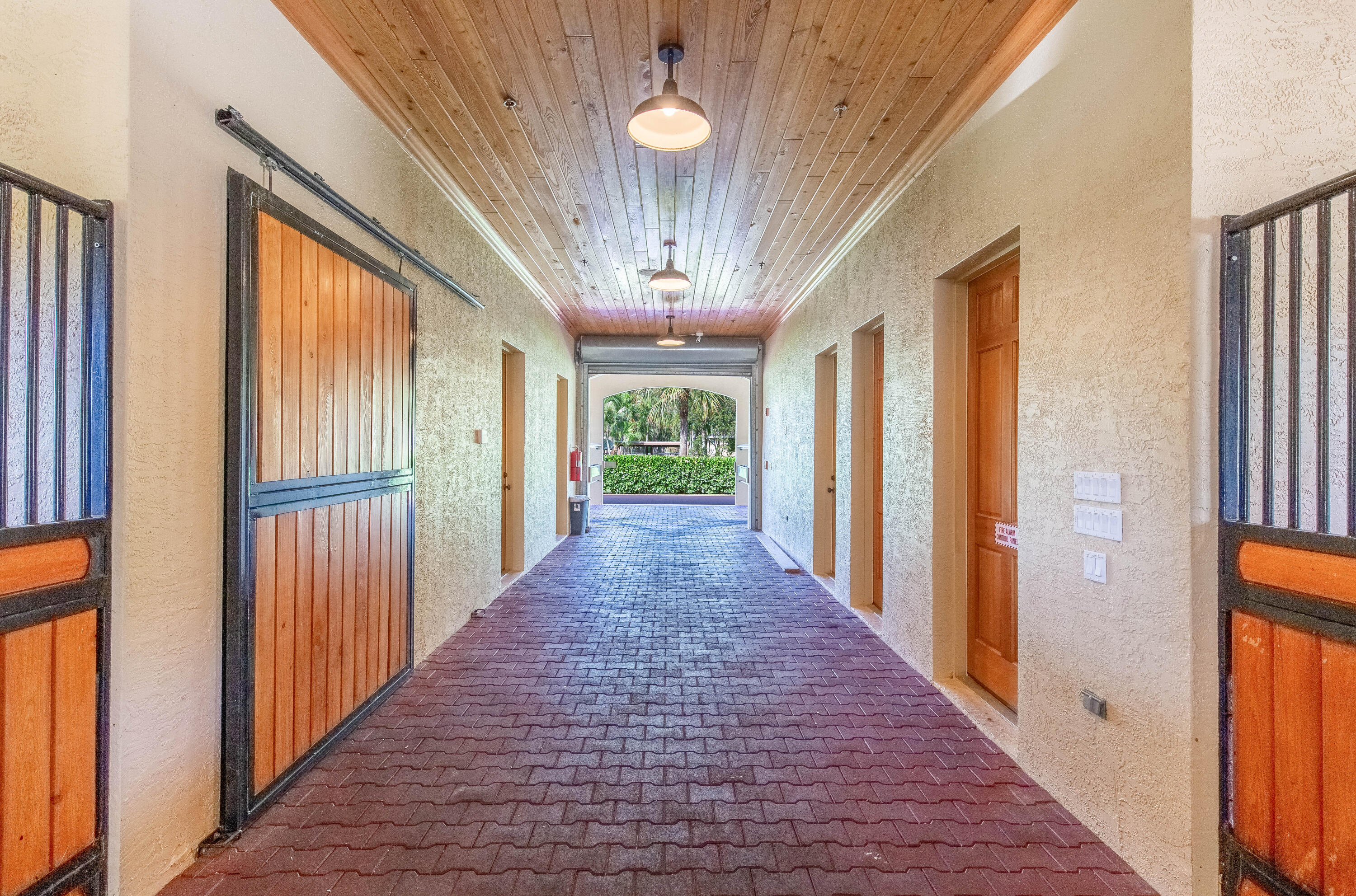 14943 Paddock Drive, Unit STALLS AND ) Wellington, FL 33414 - Photo 15 of 41 a view of a hallway with wooden floor and chandelier