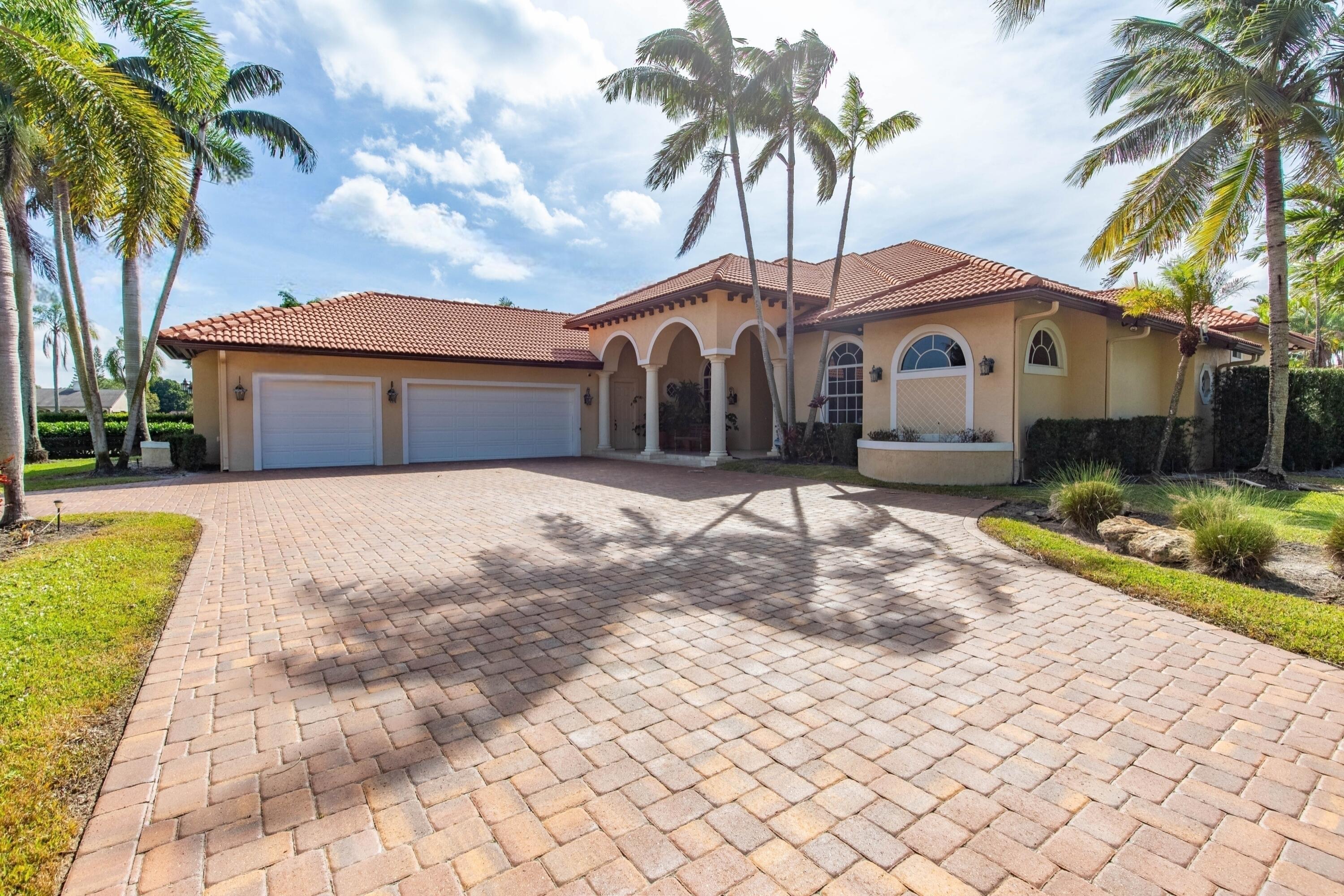 14943 Paddock Drive, Unit STALLS AND ) Wellington, FL 33414 - Photo 21 of 41 a front view of a house with a yard and garage