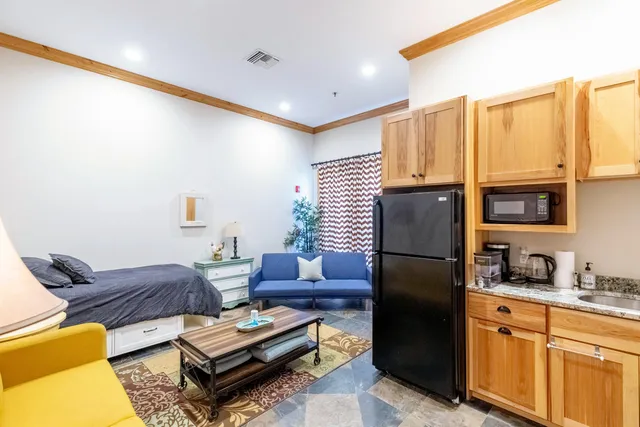a living room with a couch and a potted plant on dresser