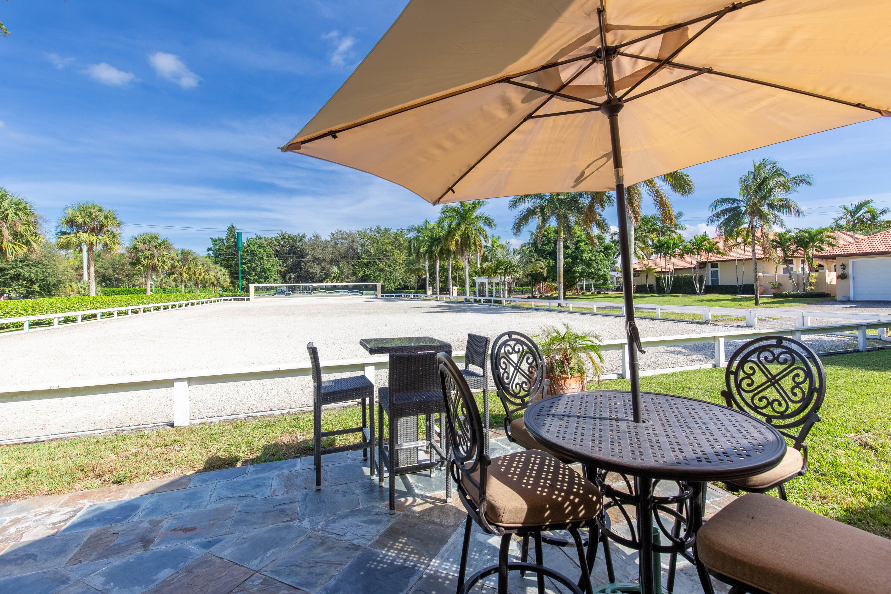 14943 Paddock Drive, Unit STALLS AND ) Wellington, FL 33414 - Photo 28 of 41 a view of a chairs and table in the patio with a lake view