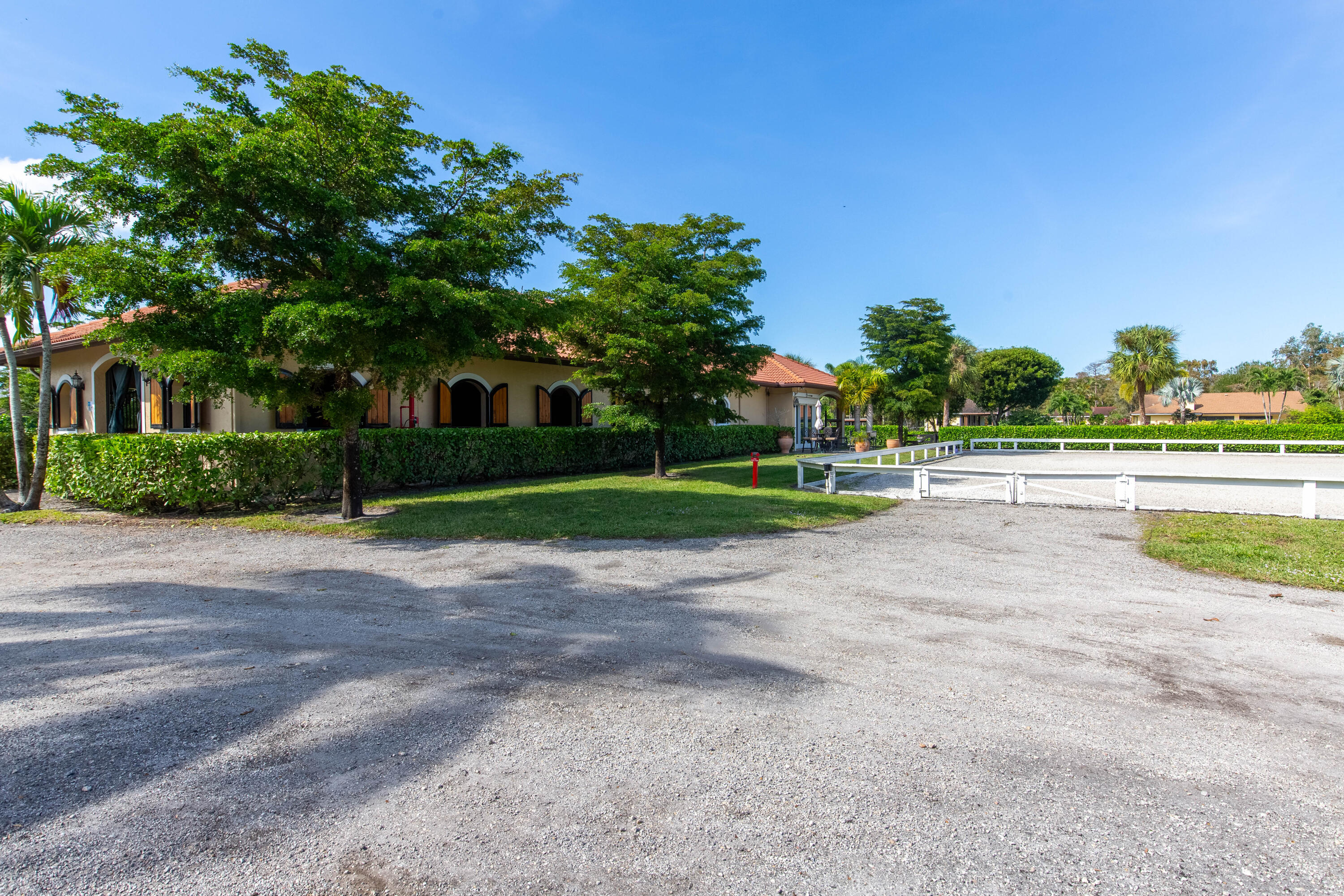 14943 Paddock Drive, Unit STALLS AND ) Wellington, FL 33414 - Photo 36 of 41 a view of a house with a yard and palm trees