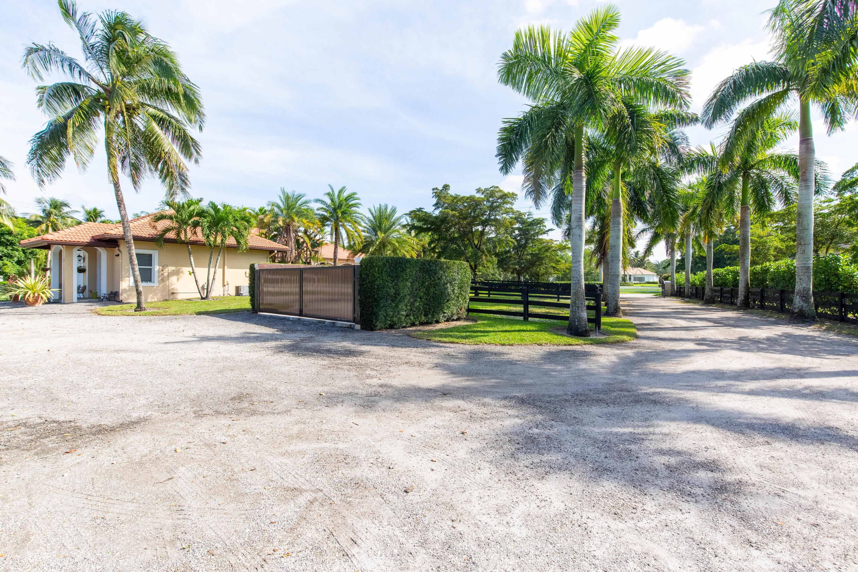 14943 Paddock Drive, Unit STALLS AND ) Wellington, FL 33414 - Photo 38 of 41 a front view of a house with a yard and a garage