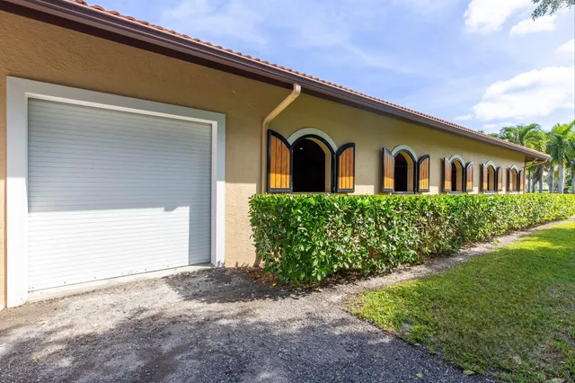 a front view of a house with a yard and palm trees