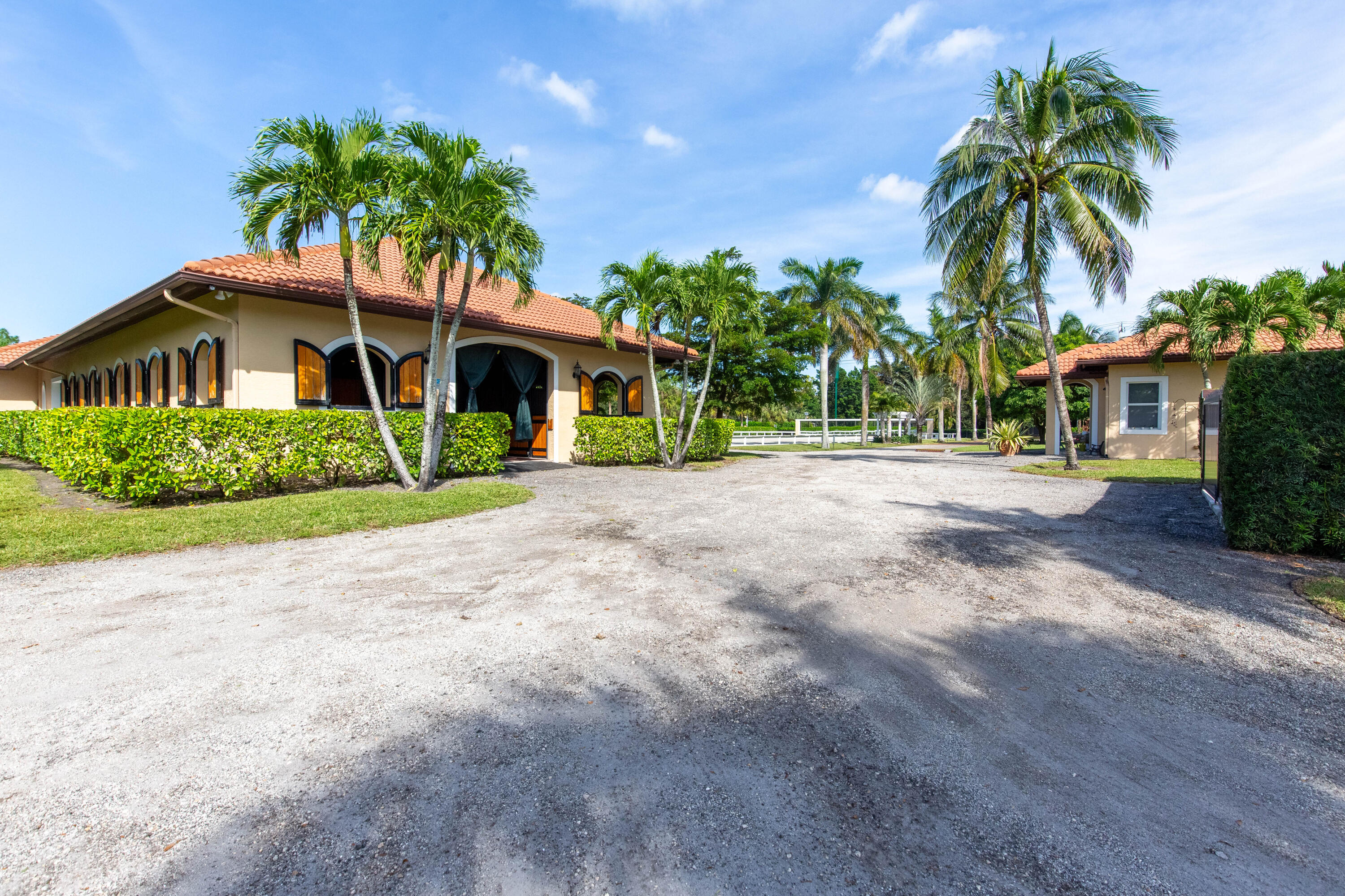 14943 Paddock Drive, Unit STALLS AND ) Wellington, FL 33414 - Photo 10 of 41 a front view of a house with a yard and palm trees