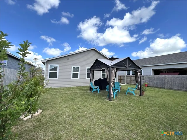 a view of a house with yard and sitting area