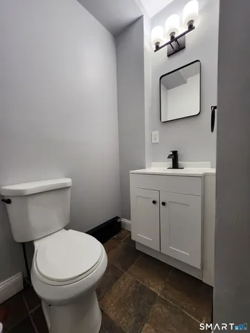 a bathroom with a toilet a sink and mirror