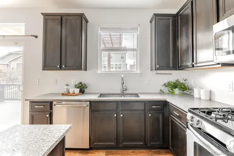 a kitchen with stainless steel appliances granite countertop a sink stove and refrigerator