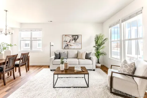 a living room with furniture wooden floor and a large window