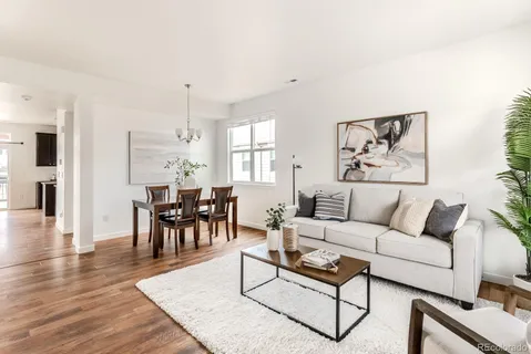 a living room with furniture and a wooden floor
