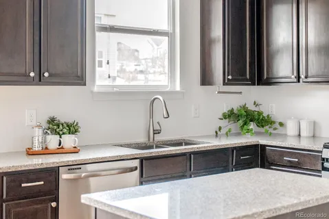 a kitchen with stainless steel appliances granite countertop a sink and a window