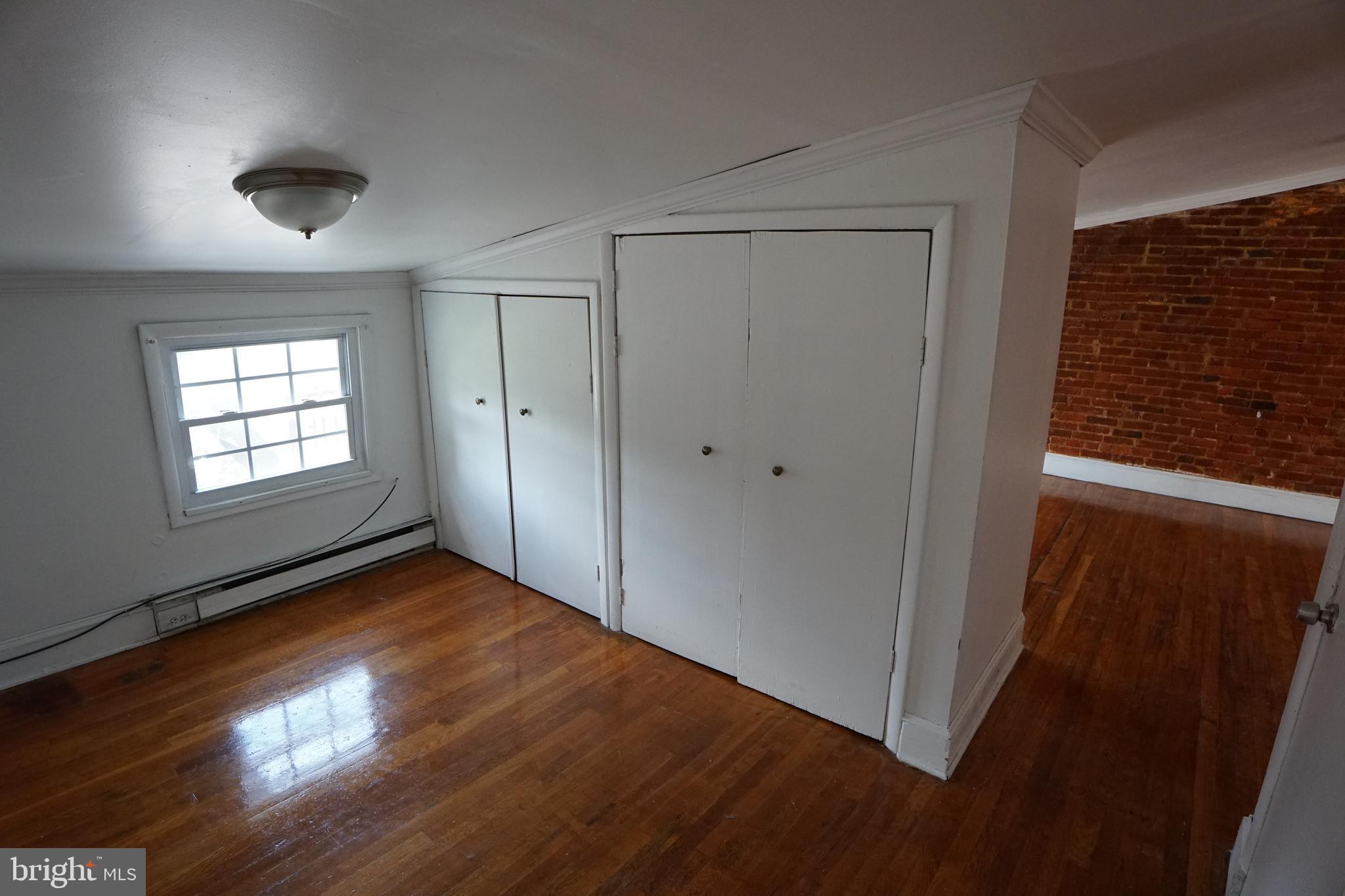 802 Cathedral Street, Unit 4 Baltimore, MD 21201 - Photo 7 of 15 wooden floor in an empty room with a window