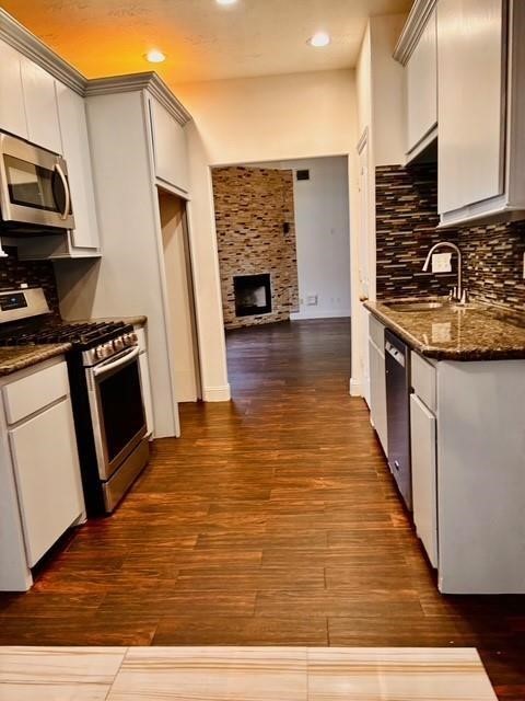 23915 Floragate Drive Spring, TX 77373 - Photo 5 of 25 a kitchen with wooden floors and stainless steel appliances