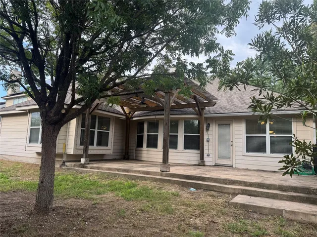 a front view of a house with a tree