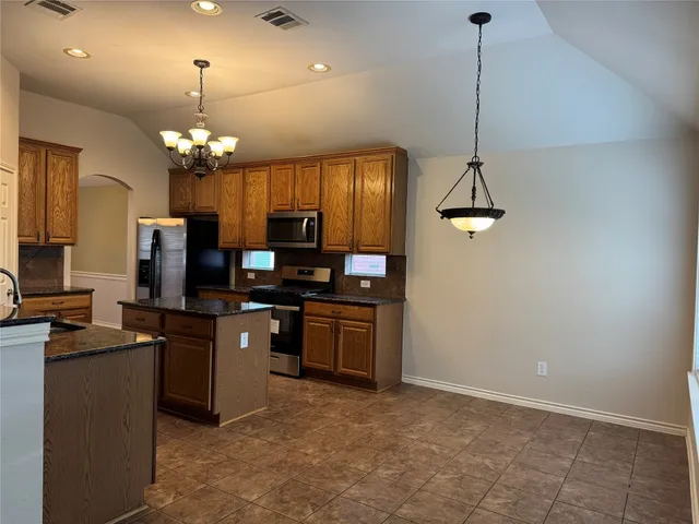a kitchen with kitchen island granite countertop stainless steel appliances lots of counter top space