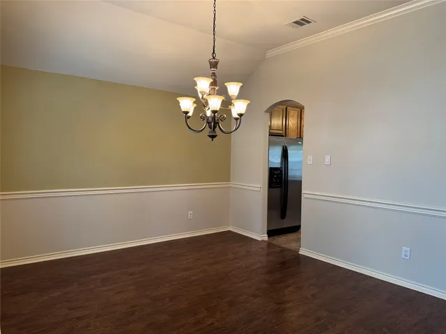 a view of a room with wooden floor and chandelier