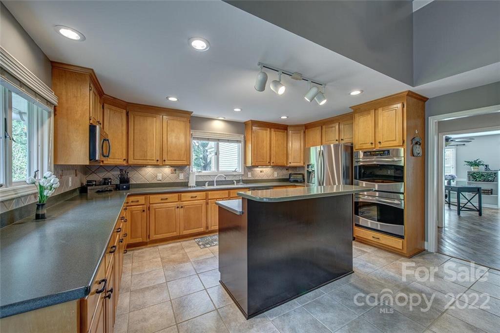 1909 3 Lakes Road Shelby, NC 28150 - Photo 13 of 48 a large kitchen with stainless steel appliances granite countertop a large counter top a stove a chimney a sink and a large window
