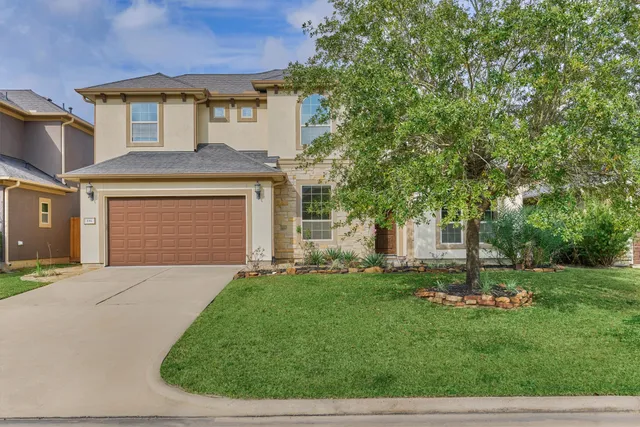 a front view of a house with a yard and trees