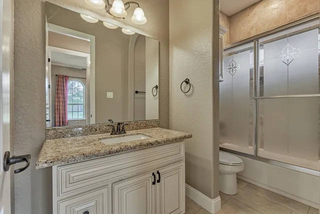 a bathroom with a toilet a sink and mirror