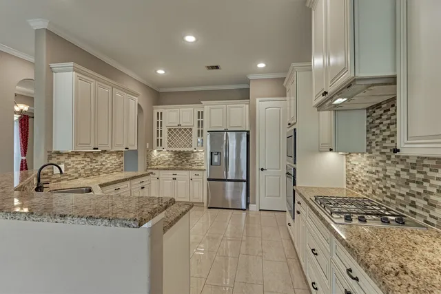 a large kitchen with stainless steel appliances granite countertop a stove and a sink