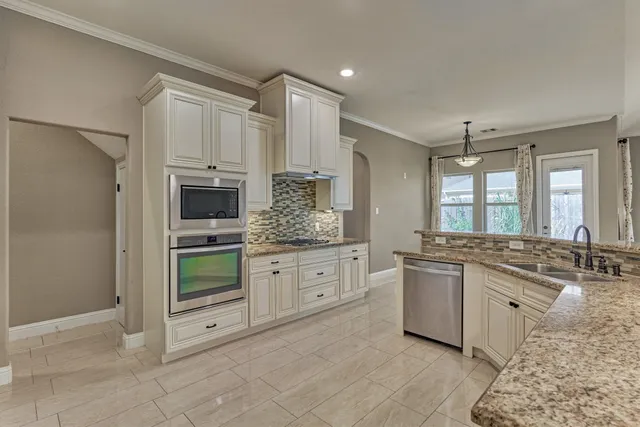 a kitchen with white cabinets and appliances