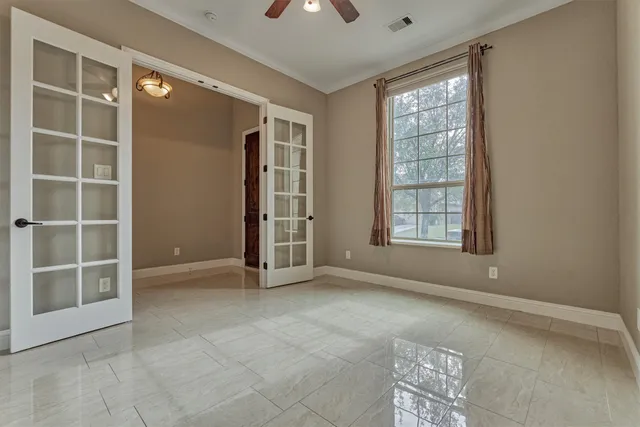 an empty room with windows and cabinet